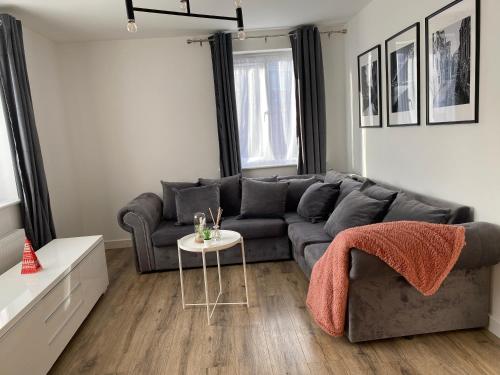 a living room with a gray couch and a table at Lovely 2 Bed flat close to South Woodham Ferrers station in Woodham Ferrers