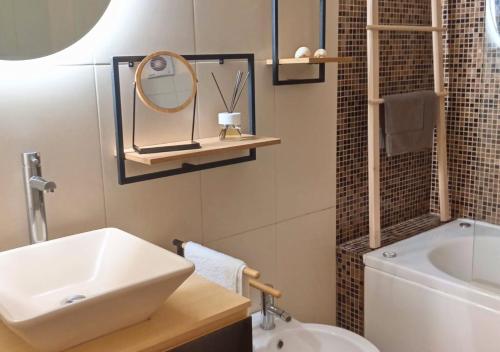 een badkamer met een wastafel, een spiegel en een bad bij Estrela do Mar in Gafanha da Nazaré