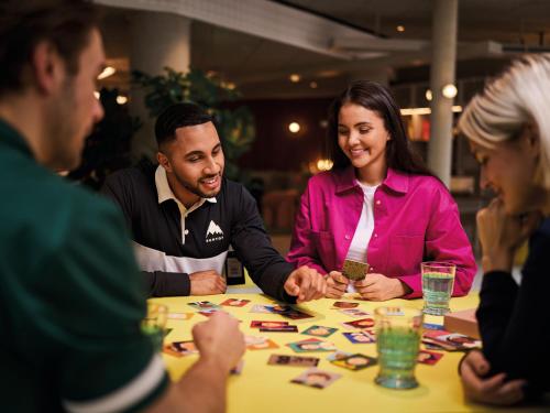 a group of people sitting around a table playing a board game at Urban Nature Bad Gastein - Badeschloss in Bad Gastein