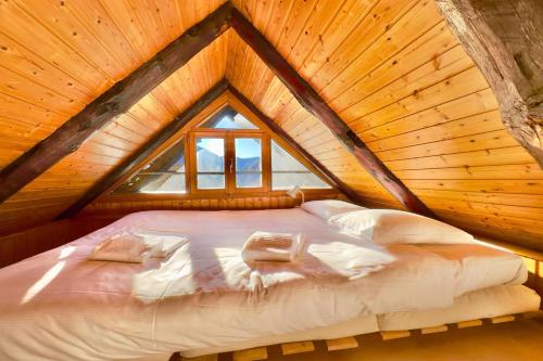 a bed in a wooden room with a roof at Rustico Caterina - Happy Rentals in Corippo