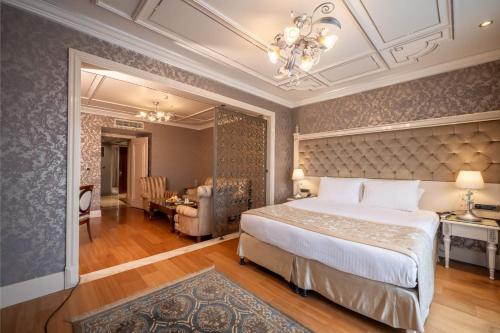 Un dormitorio con una cama grande y un comedor. en The Central Palace Taksim, en Estambul