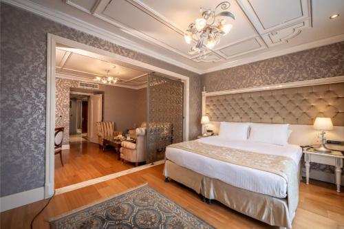 a bedroom with a large bed and a dining room at The Central Palace Taksim in Istanbul