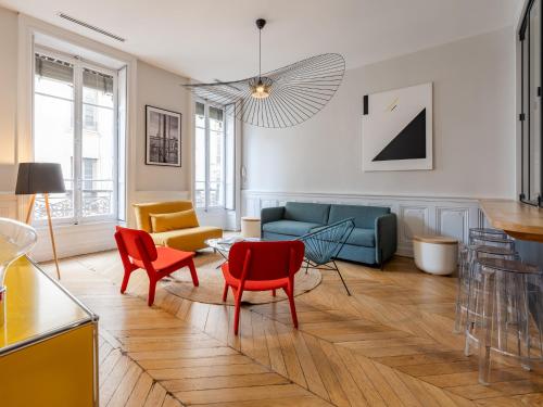 - un salon avec des chaises rouges et un canapé bleu dans l'établissement L'Atelier,T3,au pied de l'Opéra, Climatisé, CHECK-IN AUTONOME 24H sur 24H, à Lyon