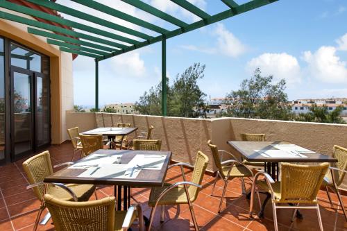 a patio with tables and chairs on a balcony at Elba Lucía Sport & Suite Hotel in Costa de Antigua