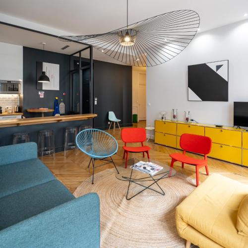 un salon avec des chaises colorées et un canapé dans l'établissement L'Atelier,T3,au pied de l'Opéra, Climatisé, CHECK-IN AUTONOME 24H sur 24H, à Lyon
