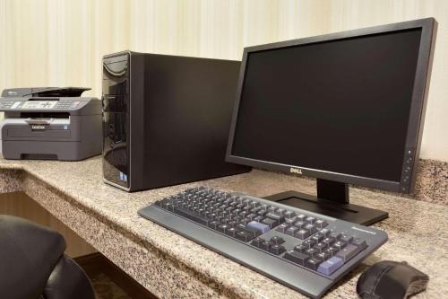 a computer monitor and a keyboard on a desk at Garner Hotel Gillette South by IHG in Gillette