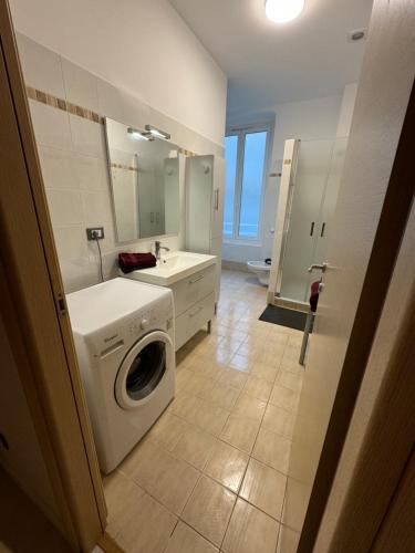 a bathroom with a washing machine and a sink at Prato Home - apartment near the beach in Menton in Menton