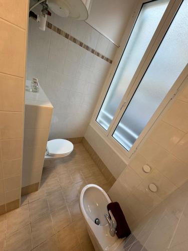 a bathroom with a sink and a toilet and a window at Prato Home - apartment near the beach in Menton in Menton