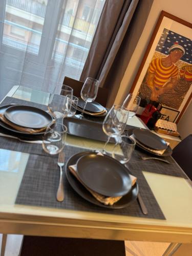 a table with plates and wine glasses on it at Prato Home - apartment near the beach in Menton in Menton