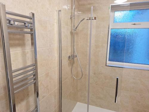 a shower with a glass door in a bathroom at Uplands Grove Bungalow in Wolverhampton