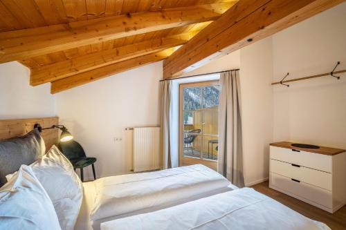 1 dormitorio con 2 camas y ventana en Mountain Residence Kasern Nr 3, en Predoi