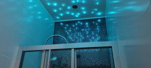 a bathroom with blue lights on the ceiling at Bulb Apartment Budapest in Budapest