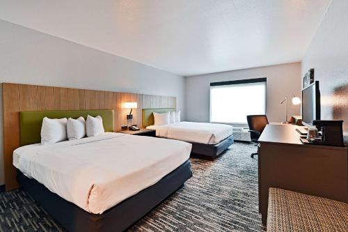 Cette chambre comprend deux lits et une télévision. dans l'établissement Country Inn & Suites by Radisson, Bloomington-Normal Airport, IL, à Bloomington