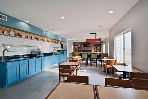 a dining room with blue cabinets and wooden tables at Country Inn & Suites by Radisson, Bloomington-Normal Airport, IL in Bloomington