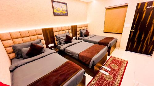 a hotel room with two beds and a mirror at The Vacation Villa in Agra