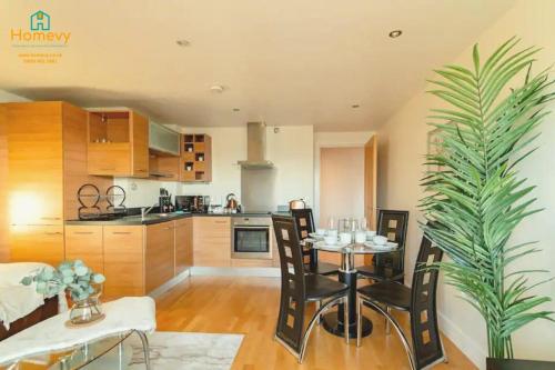 uma cozinha e sala de jantar com mesa e cadeiras em 1 Bedroom Apartment by Homevy Relocations Short Lets & Serviced Accommodation Leeds Dock - Stylish and Convenient em Leeds