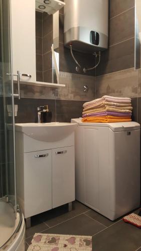 a white bathroom with a sink and a toilet at Apartment Orloj in Primo&scaron;ten