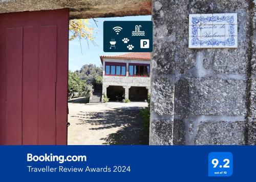 a red door with a sign next to a building at MyStay - Quinta da Balança in Terras de Bouro