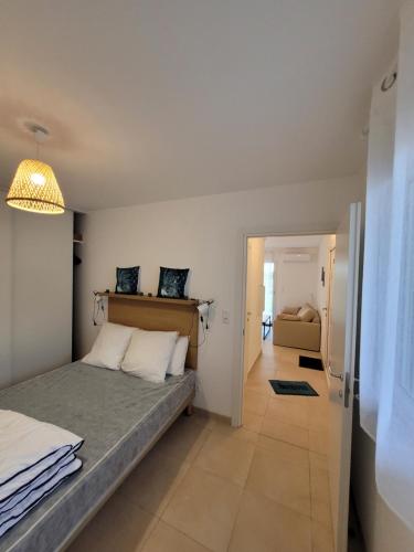 ein kleines Schlafzimmer mit einem Bett und einem Flur in der Unterkunft Superbe appartement vue mer terrasse couverte face à la mer in Linguizzetta