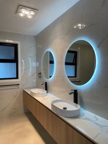 baño con 2 lavabos y espejo grande en Star in Macquarie en Weetangerra