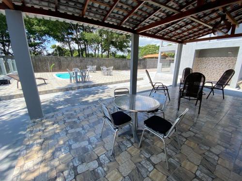 a patio with a table and chairs and a pool at Asas da Maré Pousada in Bragança