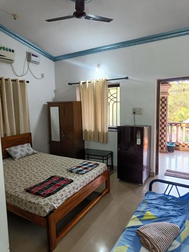 a bedroom with two beds and a window at Matilda Guest house in Calangute