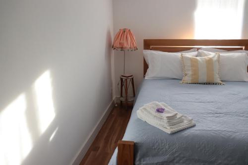 una camera da letto con un letto e un asciugamano sopra di Borboleta Guest House a Figueira de Castelo Rodrigo
