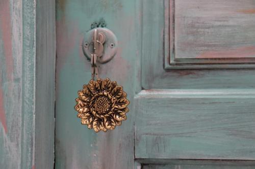 a door knocker on a blue door with a wreath at Borboleta Guest House in Figueira de Castelo Rodrigo