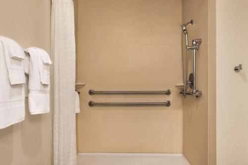 バッファローにあるCountry Inn & Suites by Radisson, Buffalo, MNのバスルーム(シャワー、白いタオル付)