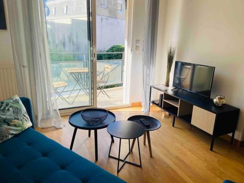 un salon avec un canapé bleu et deux tables dans l'établissement Casa Fluo, à Angers