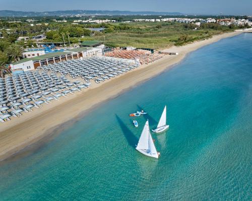 un velero en el agua junto a una playa en GranSerena Hotel, en Torre Canne