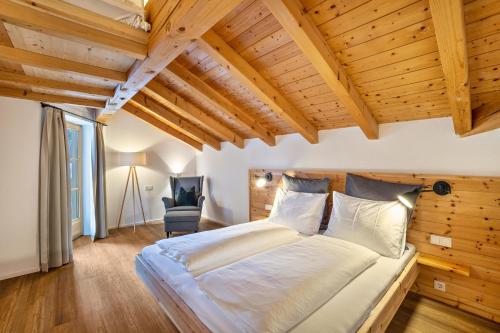 sypialnia z dużym łóżkiem w pokoju z drewnianym sufitem w obiekcie Mountain Residence Kasern Nr 4 w mieście Predoi