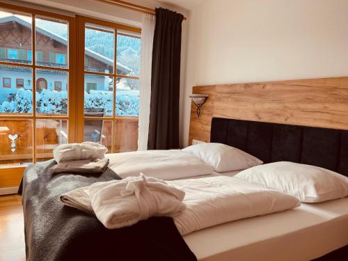 two beds in a hotel room with towels on them at Wellnesshotel Waldruh in Bad Kohlgrub