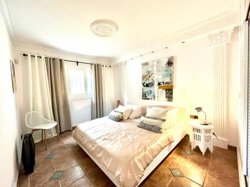 a bedroom with a bed and a chair in it at Casa Grecia in Santa Eularia des Riu