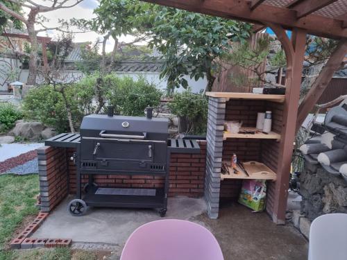 a grill in a backyard with a pergola at Yeonriji in Gyeongju