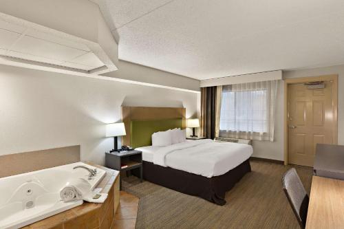 um quarto de hotel com uma cama e uma banheira em Country Inn & Suites by Radisson, Jonesborough-Johnson City West, TN em Jonesborough