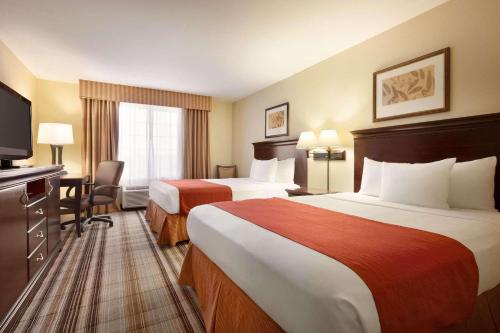 a hotel room with two beds and a flat screen tv at Country Inn & Suites by Radisson, Lexington, VA in Lexington