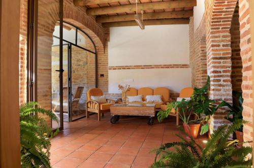 un patio con sofá y sillas en un edificio en casa rural Cieza de León, en Llerena