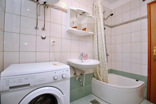 a bathroom with a washing machine and a sink at Apartment Dunato I in Šilo