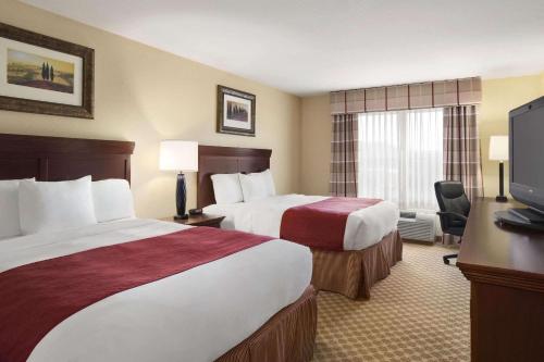 um quarto de hotel com duas camas e uma televisão em Comfort Inn & Suites em Dothan