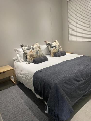 a bedroom with a large bed with pillows on it at Trendy Apartment in Durban