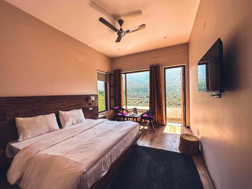 una camera con letto, ventilatore a soffitto e finestre di Clover Inn by Offlimit Homes a Shamshi