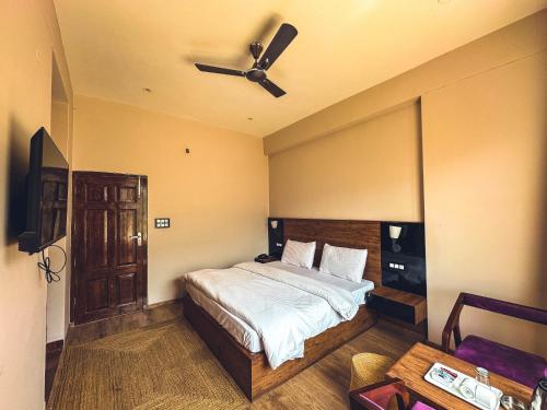 a bedroom with a bed with a ceiling fan at Clover Inn by Offlimit Homes in Shamshi