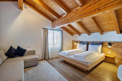 1 dormitorio con 1 cama y 1 sofá en Mountain Residence Kasern Nr 5, en Predoi