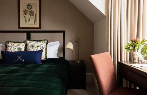 a bedroom with a bed and a desk and a chair at Rusacks St Andrews in St. Andrews