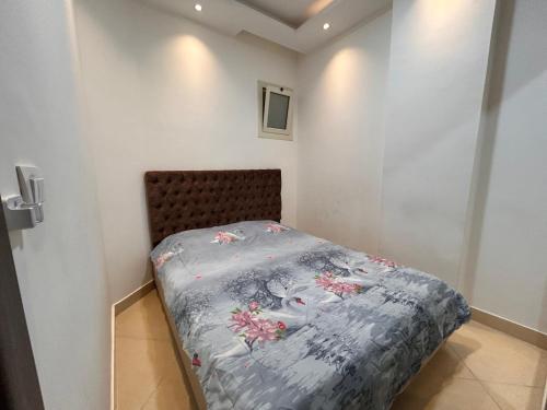Un pequeño dormitorio con una cama con flores. en Studio with private garden and pool view in Sharm Hills, en Sharm El Sheikh