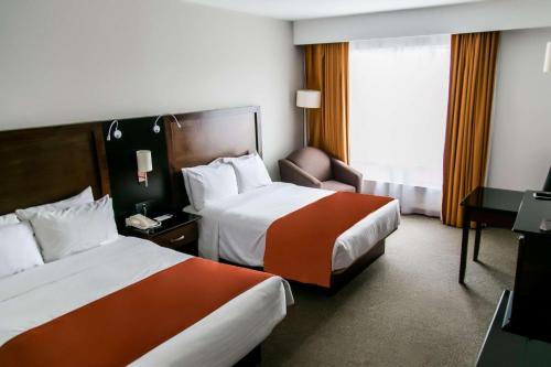 a hotel room with two beds and a window at Radisson Poliforum Plaza Hotel Leon in León