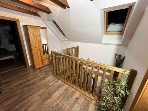 a room with a wooden staircase and a window at Chalupa pod hradom Branč in Podbranč