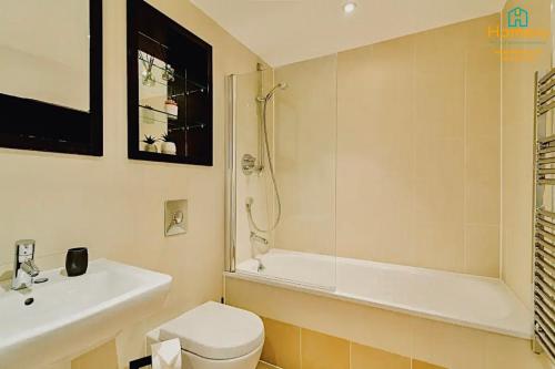 a bathroom with a toilet and a tub and a sink at 1 Bedroom Apartment by Homevy Relocations Short Lets & Serviced Accommodation Leeds Dock - Stylish and Convenient in Leeds