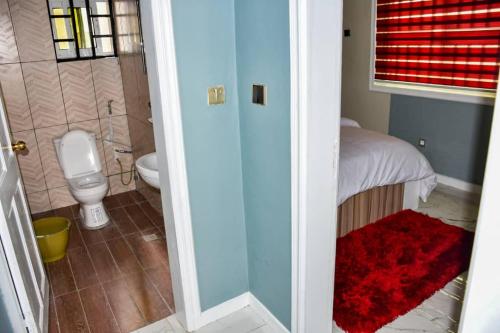 een badkamer met een toilet en een badkamer met een wastafel bij Movomo Limbe in Limbe